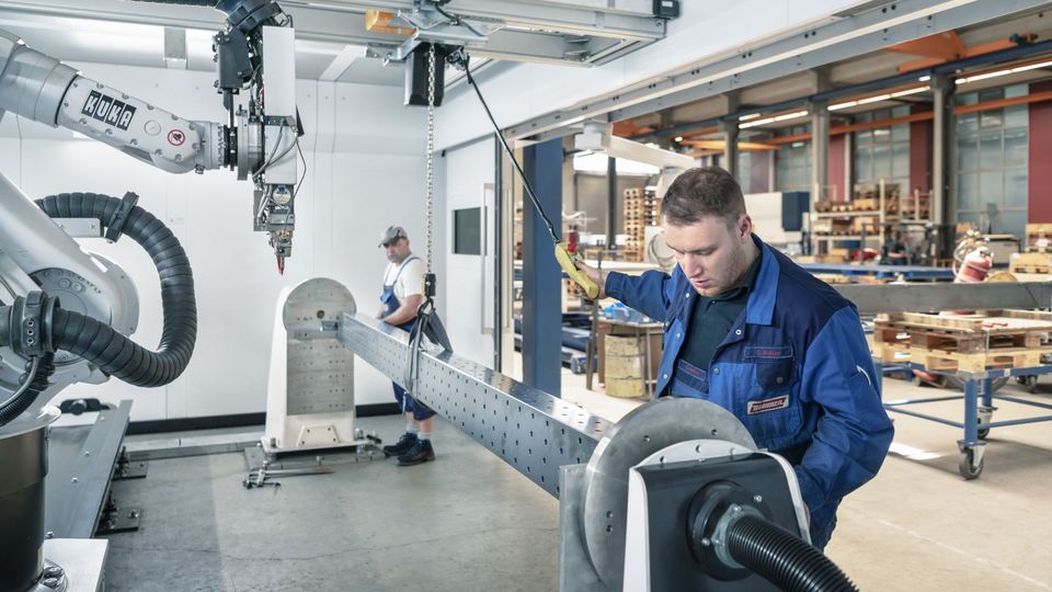 Mitarbeiter an Maschine mit großem Teil