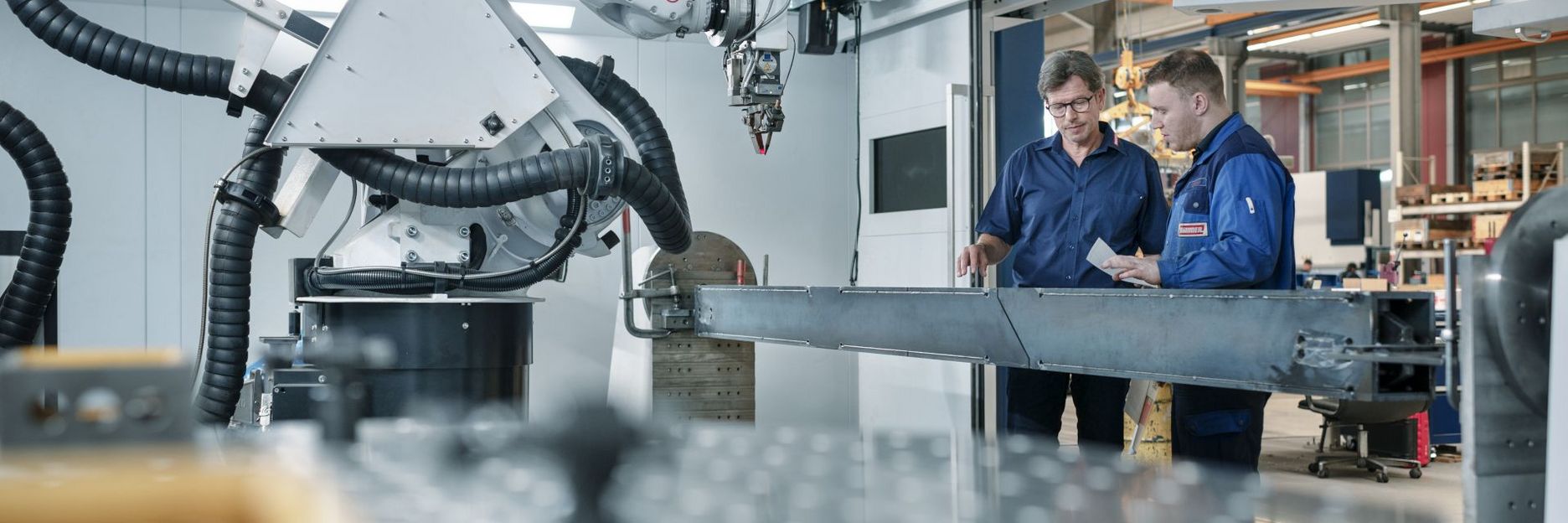 Zwei Männer an Laserschweißmaschine.