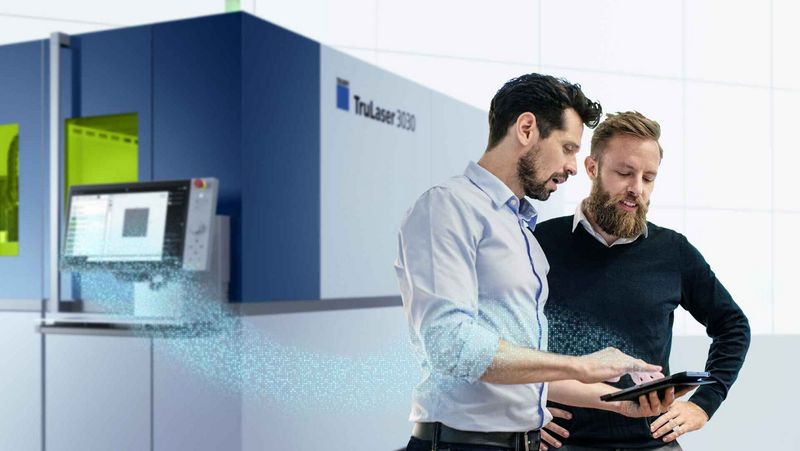 Condition Monitoring, two men looking at a tablet in front of a machine 